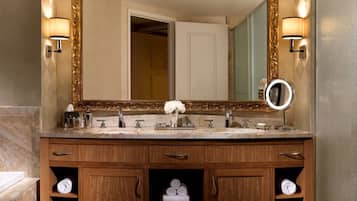 Un baño con un espejo grande, dos lavamanos y un mueble de tocador con armarios y estantes de madera.