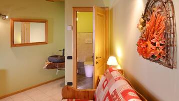 Une pièce chaleureuse avec un plafond en bois, un canapé à motifs, un miroir et un élément décoratif mural.