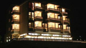 A multi-story hotel with balconies and illuminated windows at night. - Aparthotel Astoria (Seget)