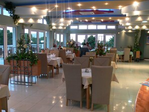 A restaurant with multiple tables, chairs, and a ceiling with lights. - Aparthotel Astoria (Seget)