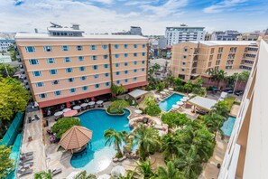 Un hôtel à plusieurs étages, doté d’une piscine et d’espaces extérieurs aménagés pour se détendre.