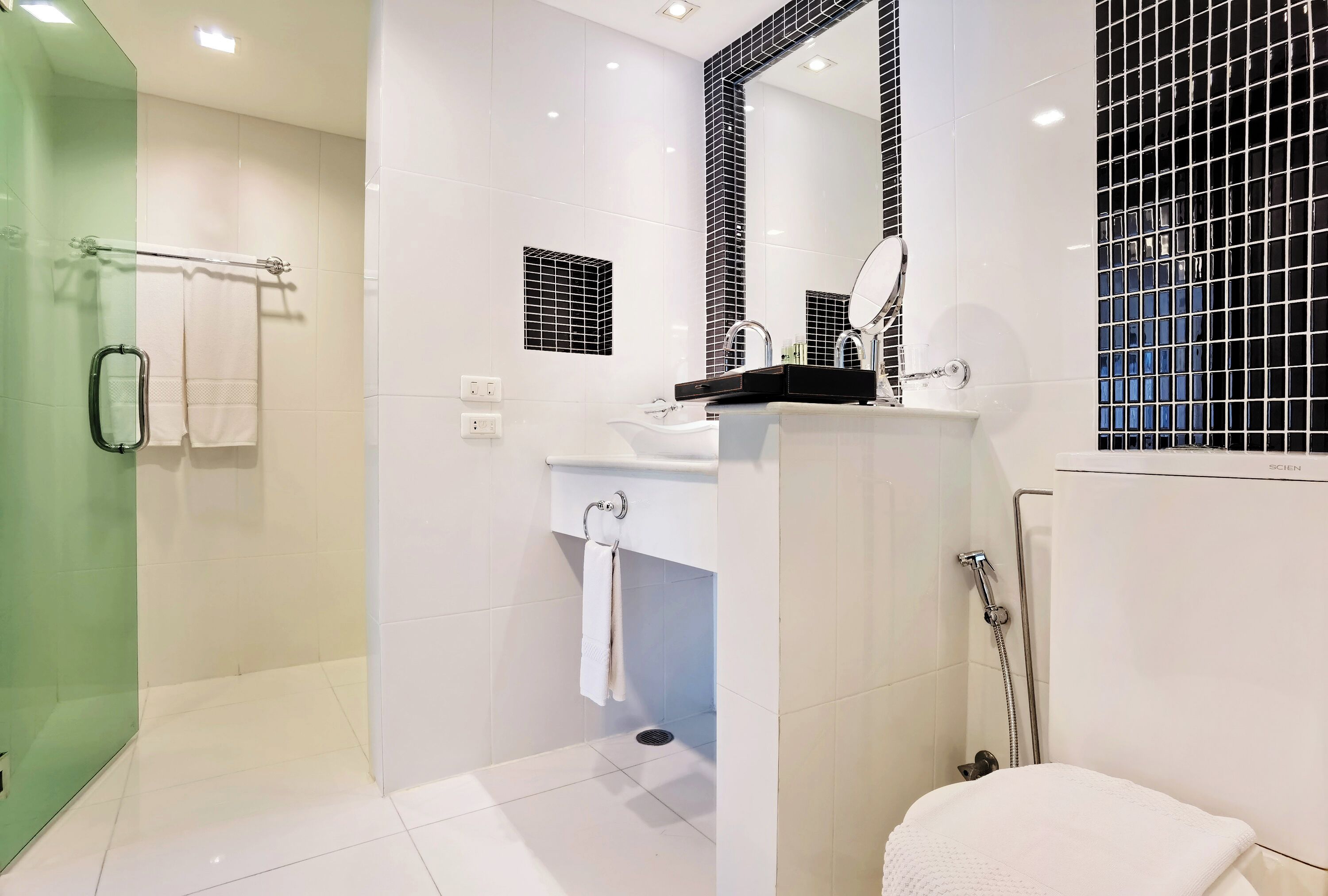 A modern bathroom with a shower, sink, and toilet.