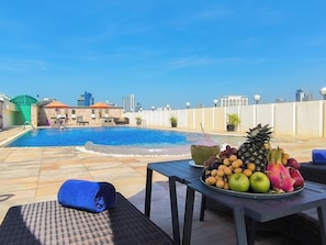 Una piscina al aire libre, sillones reclinables de piscina