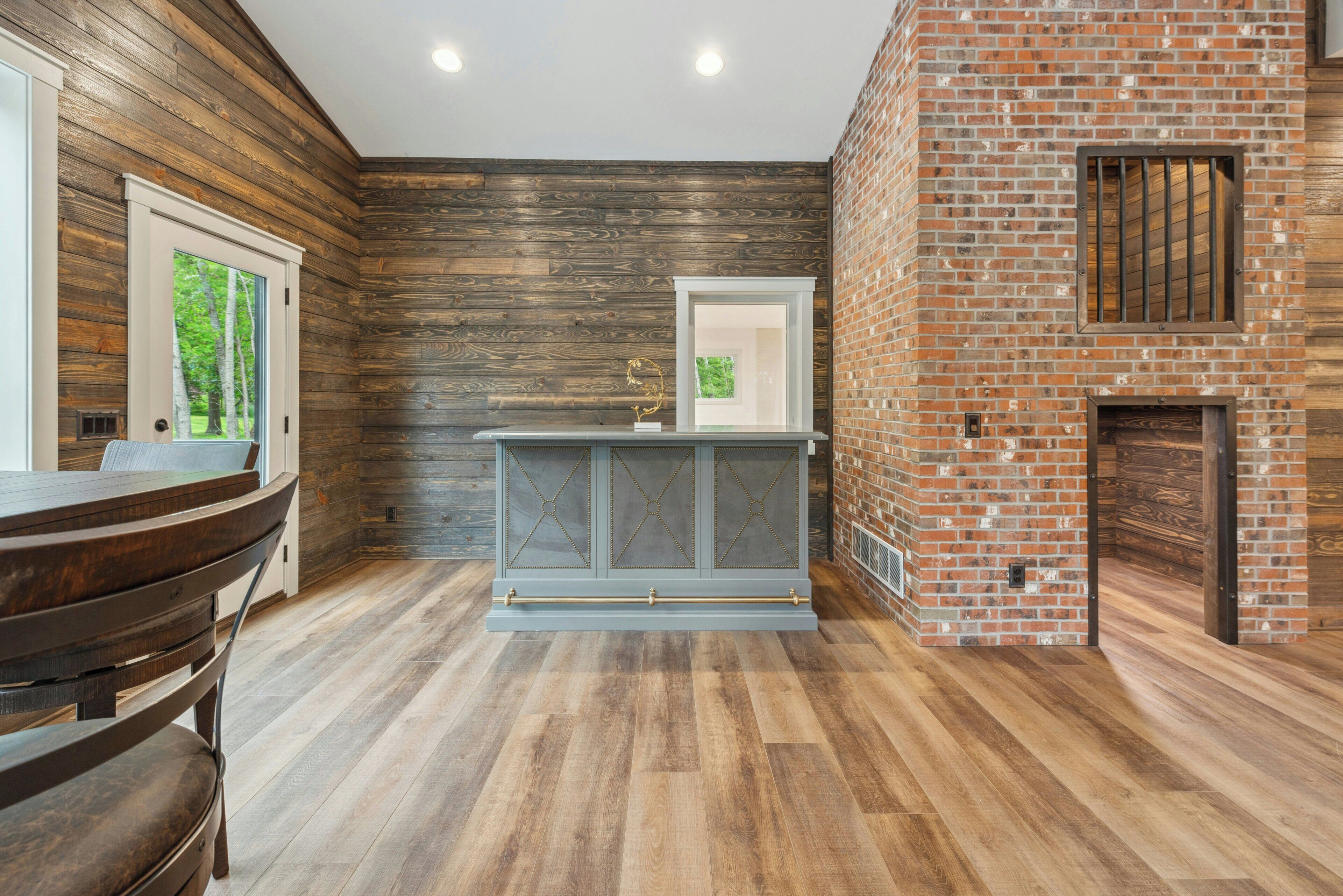 Une cuisine moderne avec un mur en bois, un mur en briques et un plancher en bois.