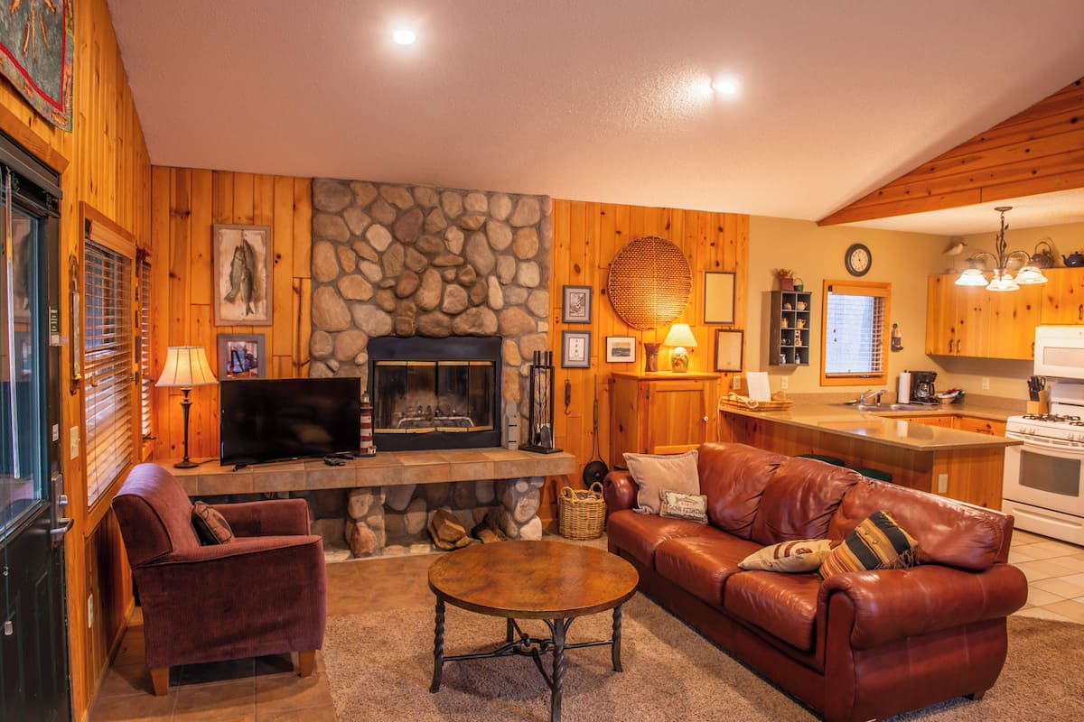 Ein gemütliches Wohnzimmer mit Kamin, Ledersofa und Fernseher.