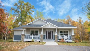 A single-story house with a front porch, a garage door, and a driveway.