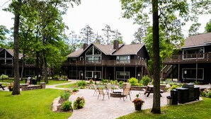 A large, two-story building with a covered patio area featuring outdoor seating and a barbecue grill.