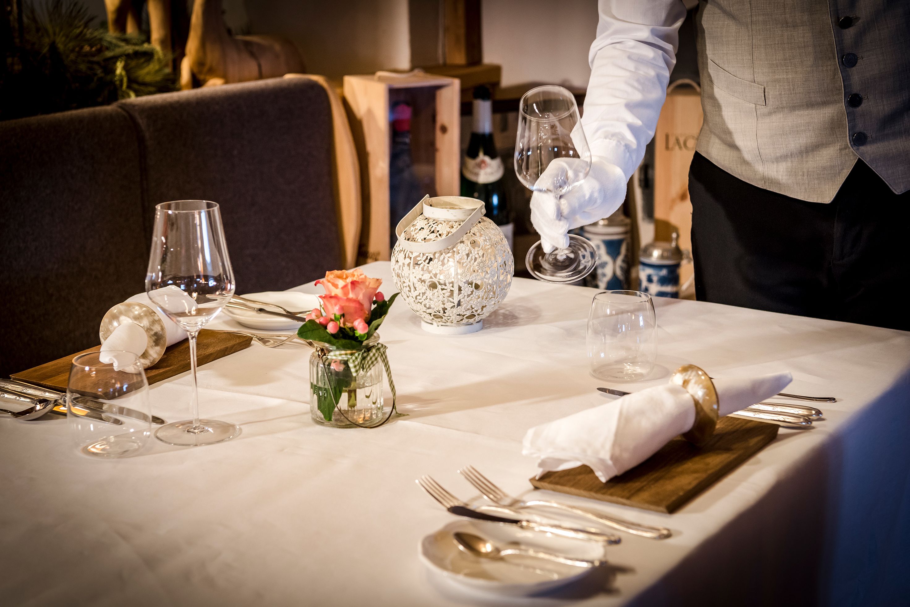 A table set for dining with a wine bottle, glasses, and a decorative vase.