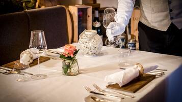 A table set for dining with a wine bottle, glasses, and a decorative vase.