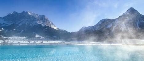 A clear blue pool with mountains in the background.