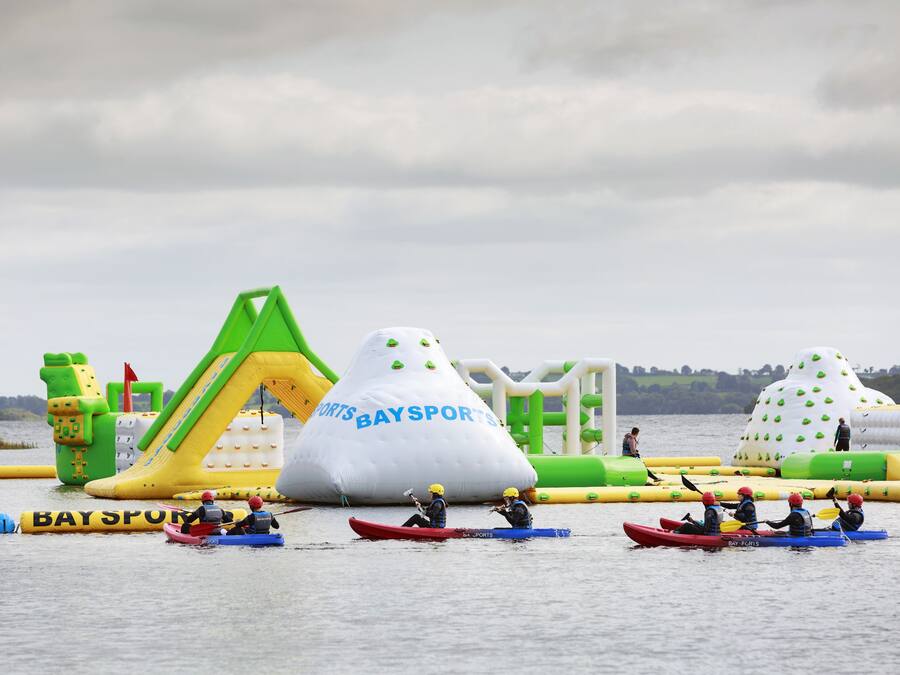 Een recreatiegebied met wateractiviteiten, opblaasbare constructies en kano's.