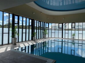Una piscina techada, sillones reclinables de piscina