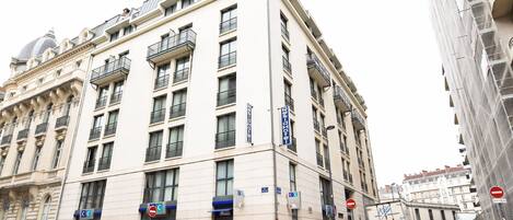 Un hotel de varios pisos con un estilo arquitectónico clásico, que cuenta con balcones y una cúpula destacada.