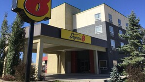 Un hotel Super 8 con un letrero llamativo, una entrada cubierta y una fachada de edificio moderna.
