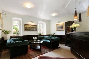 Relax in this stylish living room with a plush sofa, round coffee table, and framed artwork.