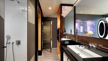 Un baño moderno con un espejo grande, dos lavamanos y una zona de ducha.