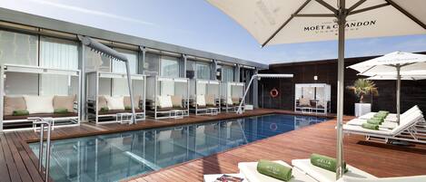 Een seizoensgebonden buitenzwembad, parasols voor strand/zwembad