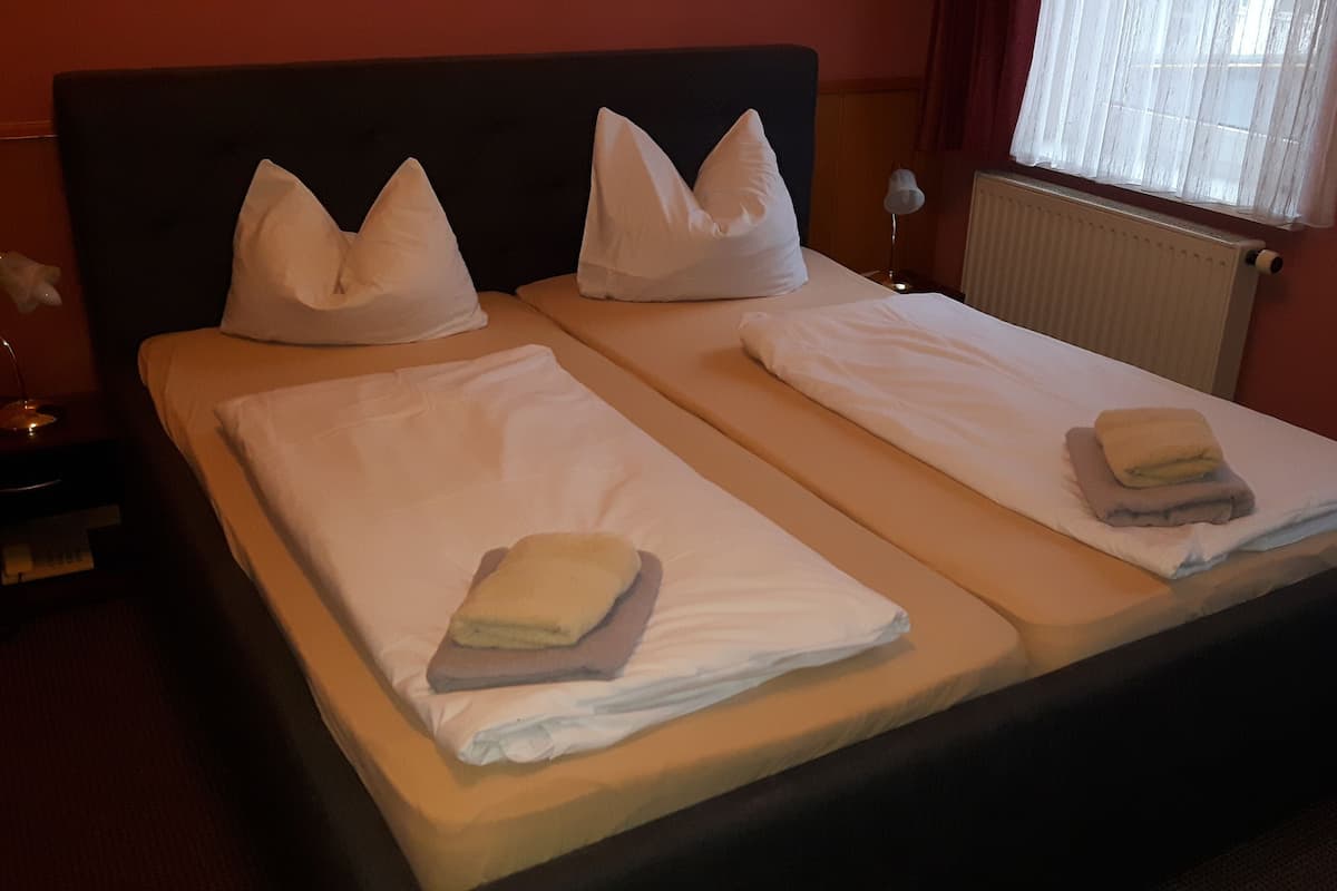 Ein Doppelbett mit zwei Kissen und gefalteten Handtüchern.