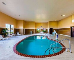 Una piscina techada, sillones reclinables de piscina