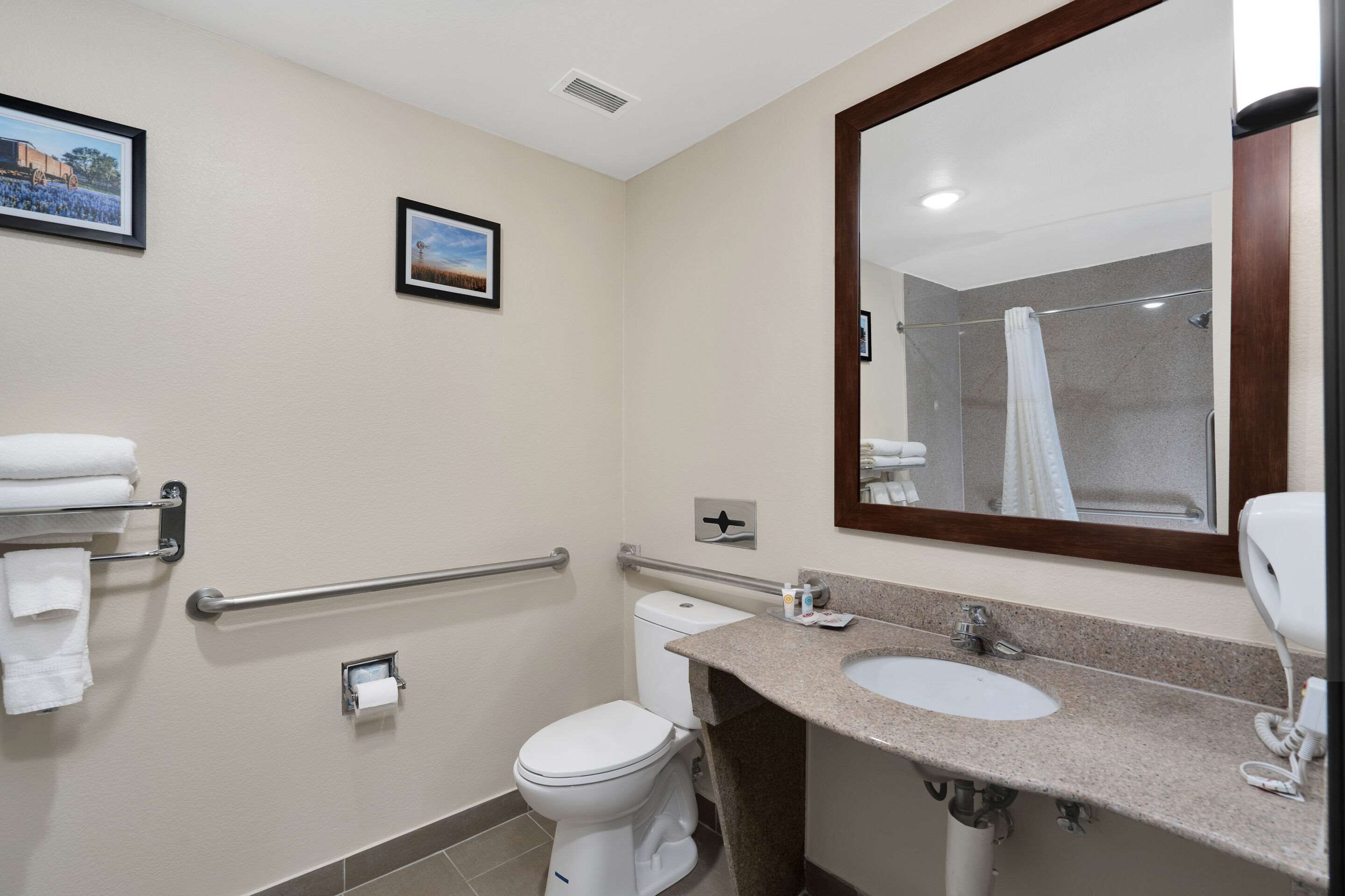 A bathroom with a toilet, sink, and shower.