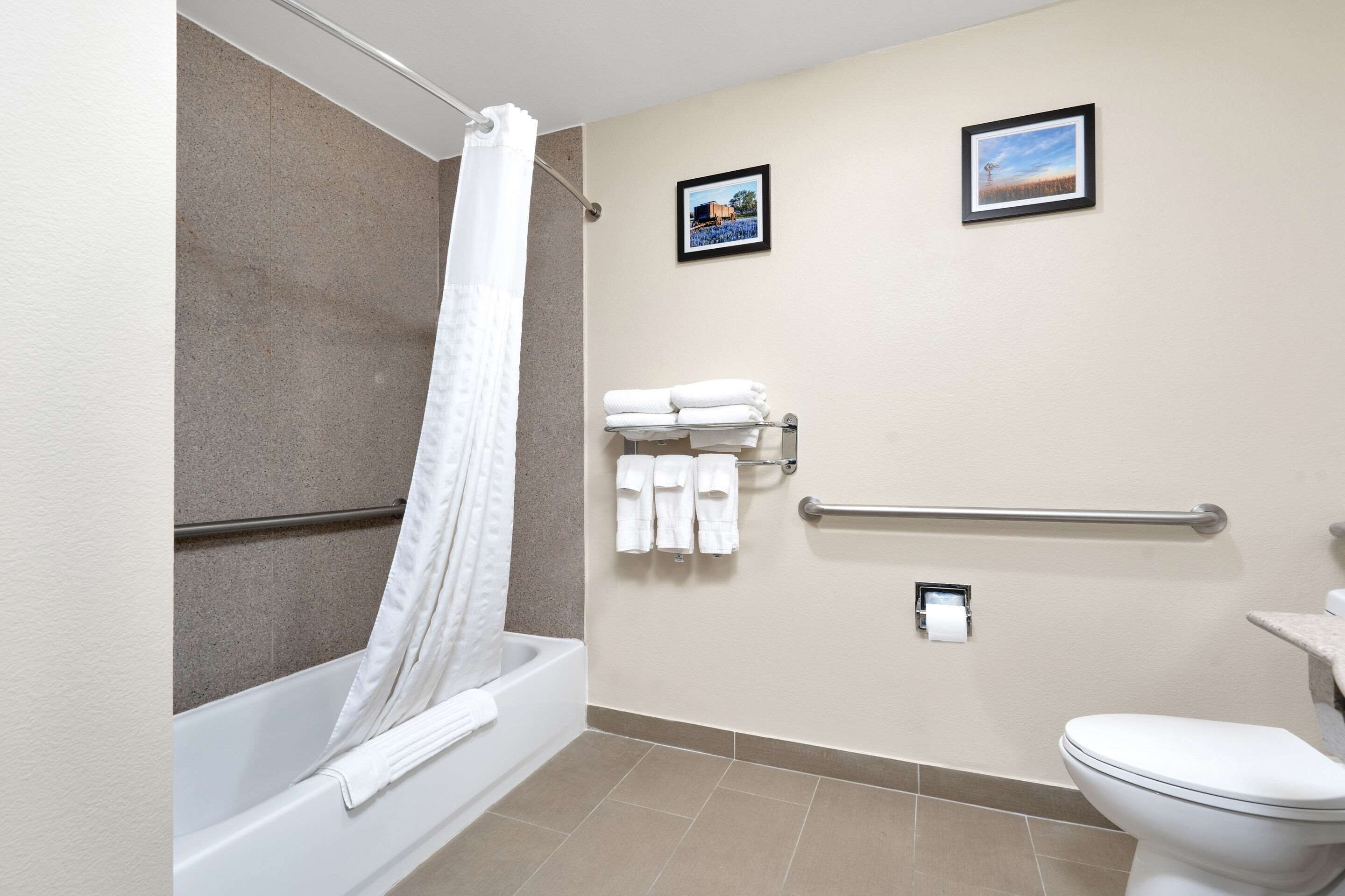 A bathroom with a bathtub, toilet, and towel rack.
