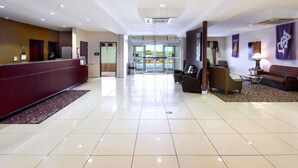 A hotel lobby with a reception desk, seating area, and a view of the parking lot. - Comfort Suites University (Abilene)
