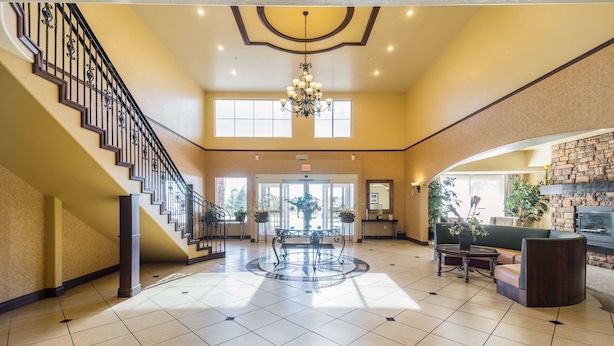 A spacious lobby with a grand staircase, a chandelier, and a fireplace. - Comfort Inn & Suites Cedar City South (Cedar City)