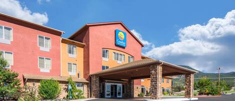 A Comfort Inn & Suites hotel with a red and yellow facade, a covered entrance, and a parking lot.