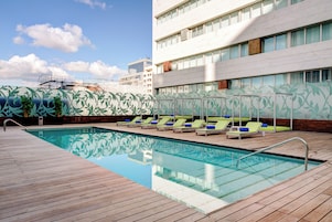 Area piscina con lettini e solarium in legno.