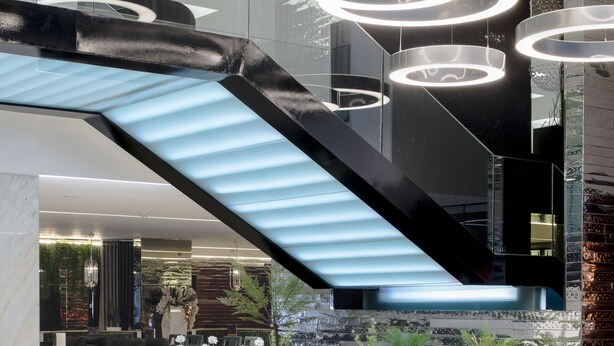 A modern lobby with a glass staircase, circular ceiling lights, and indoor plants. - VIP Grand Lisboa Hotel & Spa (Lisbon)