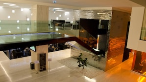 A modern interior with a glass railing, a staircase, and a reception desk. - VIP Grand Lisboa Hotel & Spa (Lisbon)