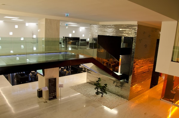A modern interior with a glass railing, a staircase, and a reception desk. - VIP Grand Lisboa Hotel & Spa (Lisbon)