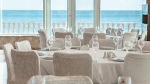 Un restaurante con mesas dispuestas para comer, con vista al mar.