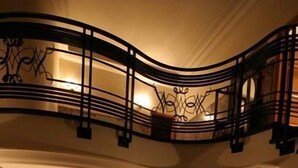 Un lobby espacioso con una escalera curva, zona de estar y chimenea.
