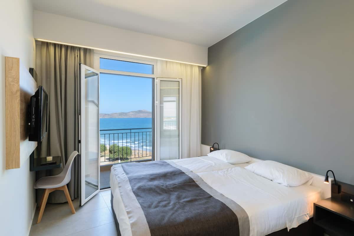 Ein modernes Hotelzimmer mit einem Bett, einem Schreibtisch mit Stuhl und einem Fernseher.