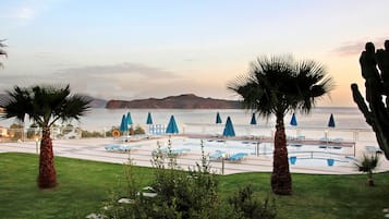 Een buitenzwembad, parasols voor strand/zwembad