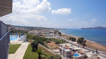 Ein Küstenhotel mit Pool, Zugang zum Strand und Blick auf das Meer und die Stadtlandschaft.