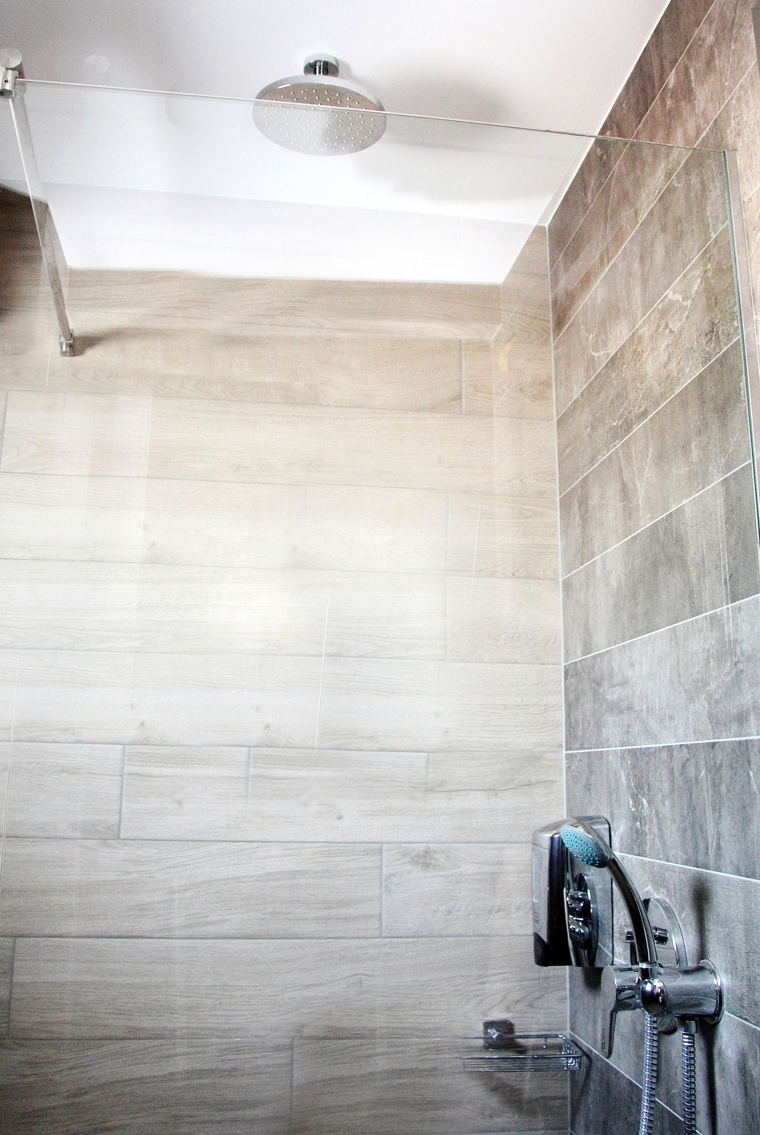 A modern shower with a handheld showerhead and a fixed overhead rain shower head.