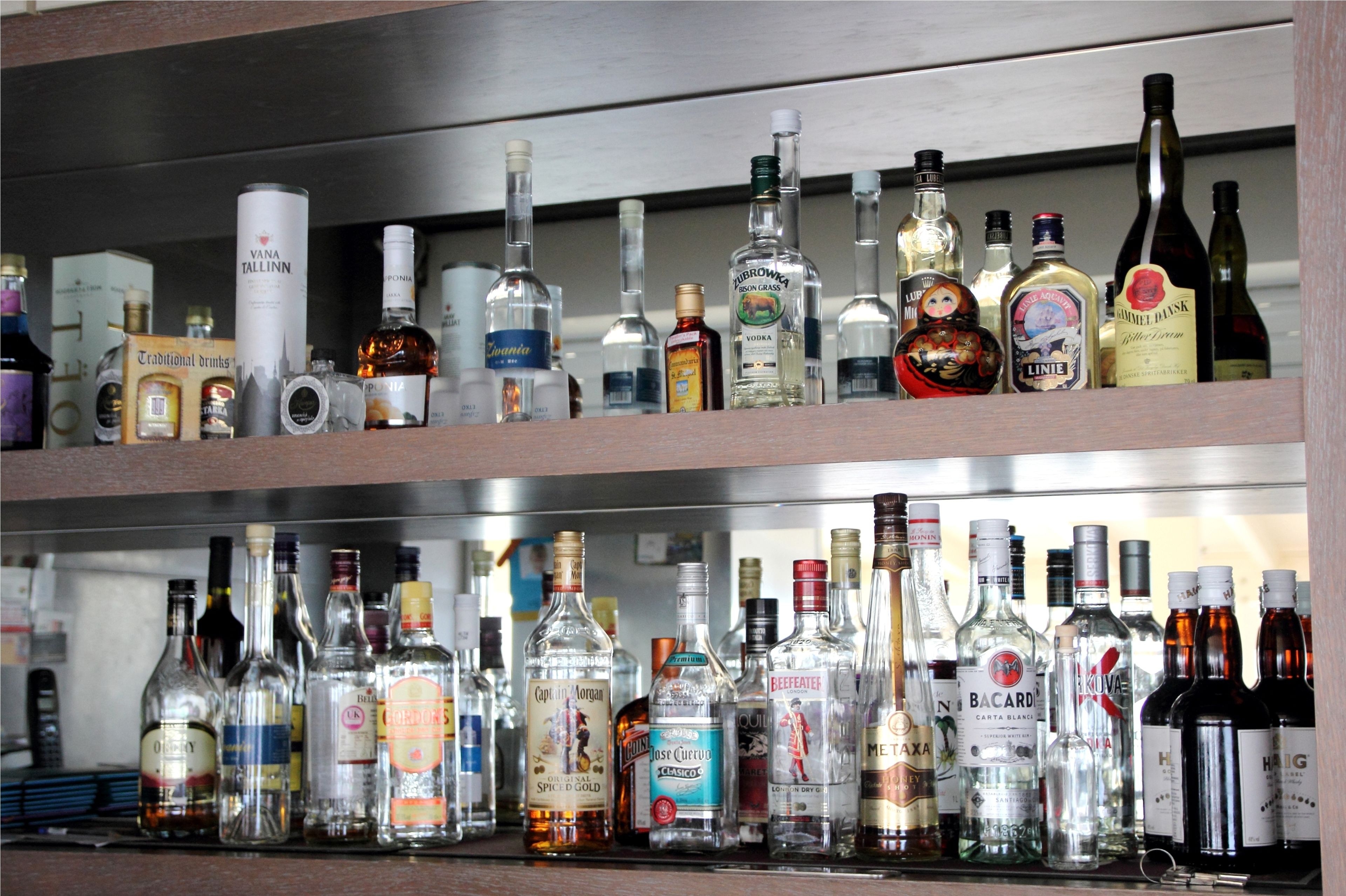 Un bar con varias estanterías llenas de botellas de licores.