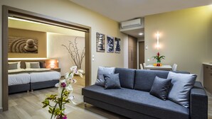 Een moderne woonkamer met een bank, een bed en een eethoek.