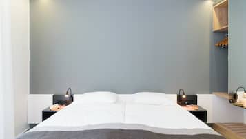 A modern bedroom with a large bed, two bedside tables, and a built-in shelf with a mirror.