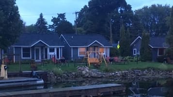 A row of cabins with a dock and a calm body of water in the foreground.