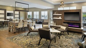 A modern hotel lobby with a large seating area, a flat-screen TV, and a fireplace. - Residence Inn Tampa Suncoast Parkway at NorthPointe Village (Lutz)