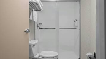 A modern bathroom with a toilet, a shower enclosure, and a towel rack.