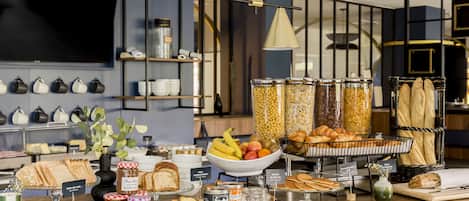 Ein reichhaltiges Buffet mit verschiedenen Speisen, darunter Brot, Gebäck und Früchte.