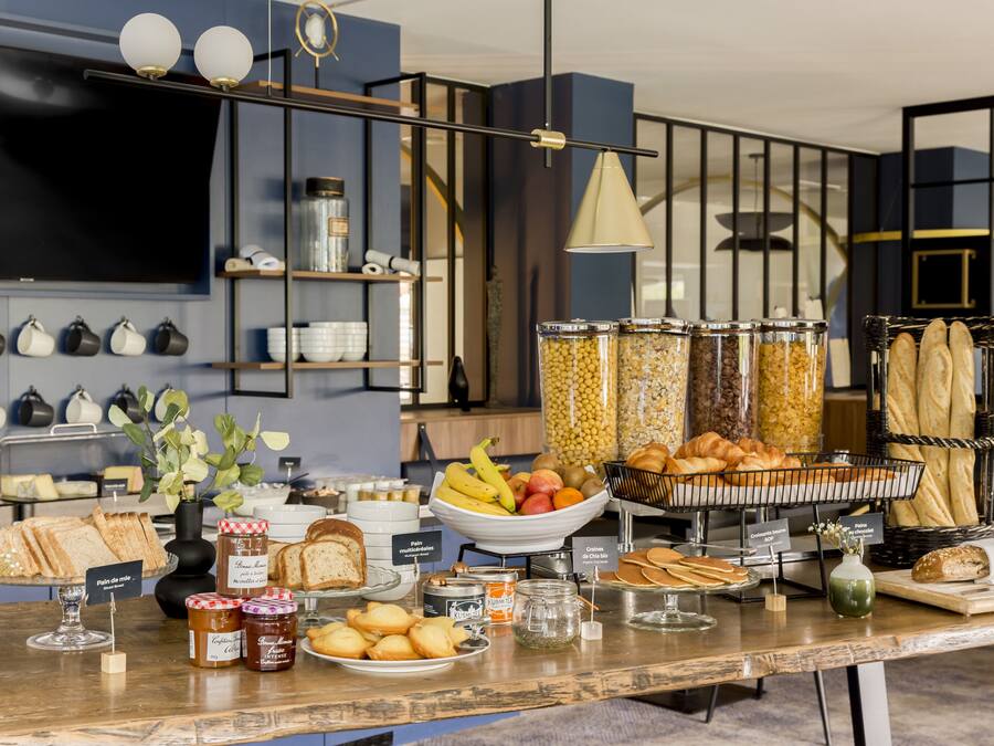 A buffet with various food items, including bread, pastries, and fruits.