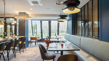 Ein modernes Restaurant mit einer langen Theke, mehreren Tischen und einer Sitzgelegenheit mit Bänken.