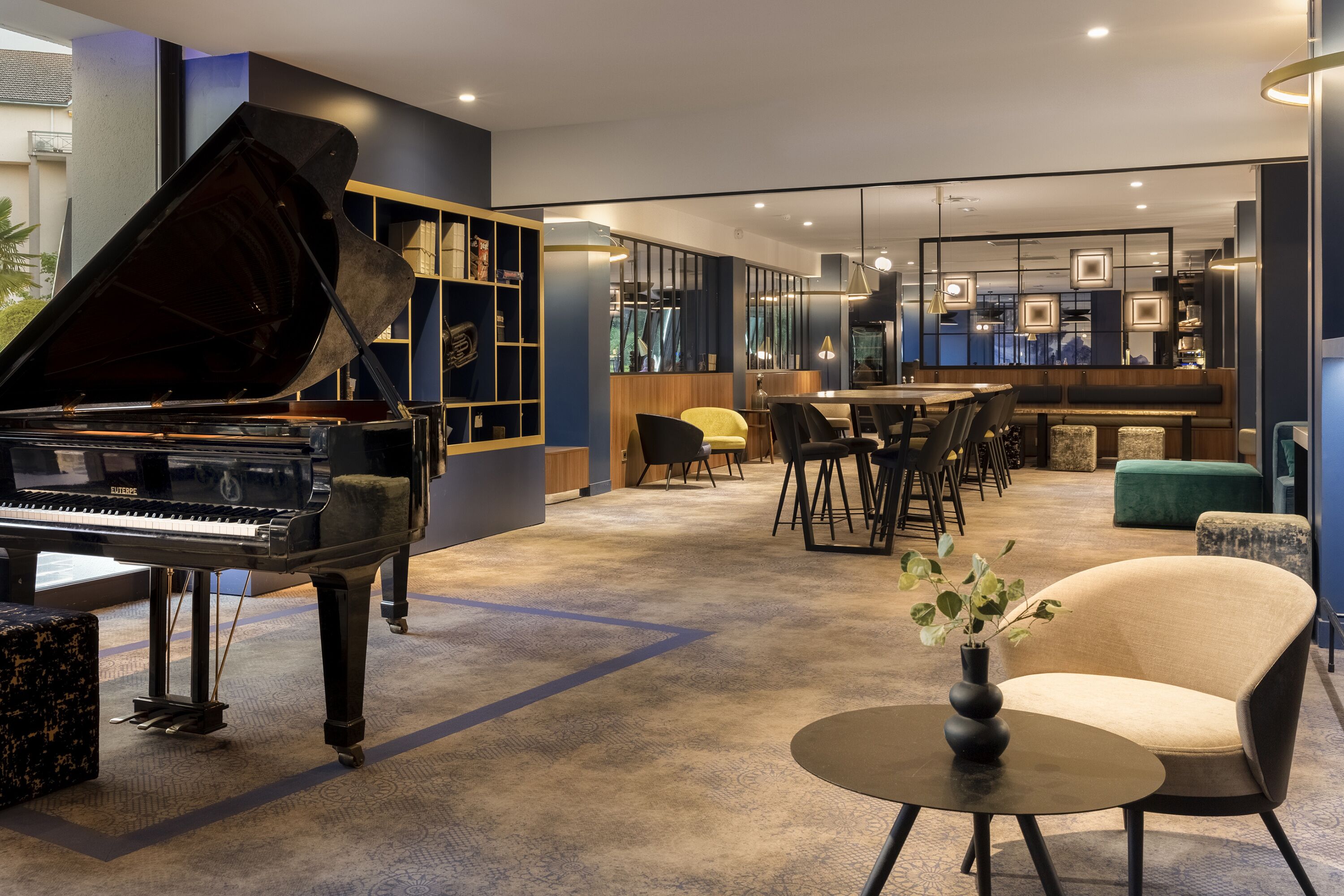 A modern interior with a grand piano, a bar area, and seating arrangements.