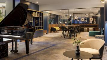A modern interior with a grand piano, a bar area, and seating arrangements.