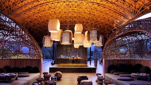 Un interior espacioso y moderno, con un techo alto en arco y un escenario central.